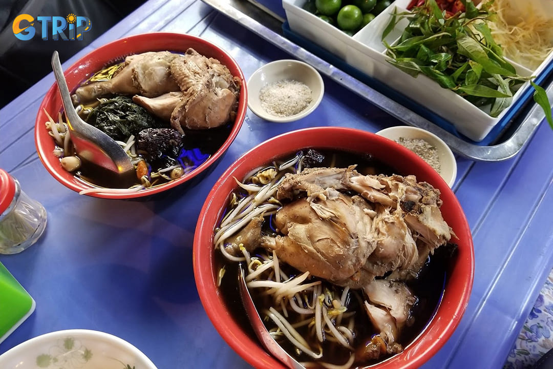 Mi ga tan is a nourishing Hanoi soup of black chicken simmered with medicinal herbs, goji berries, and jujubes, served with comforting egg noodles