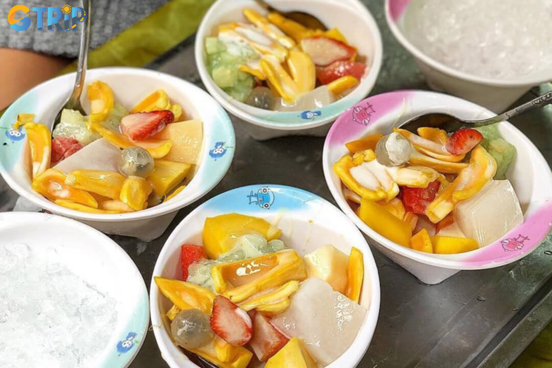 Sua chua deo hoa qua at Tuan Cafe offers chewy yogurt cubes topped with fresh fruits for a refreshing Hanoi dessert