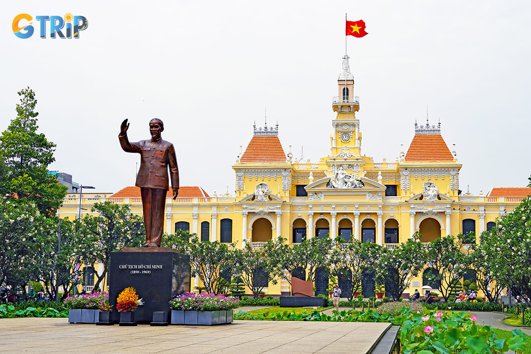 A bronze statue of Ho Chi Minh stands prominently in front of the city hall