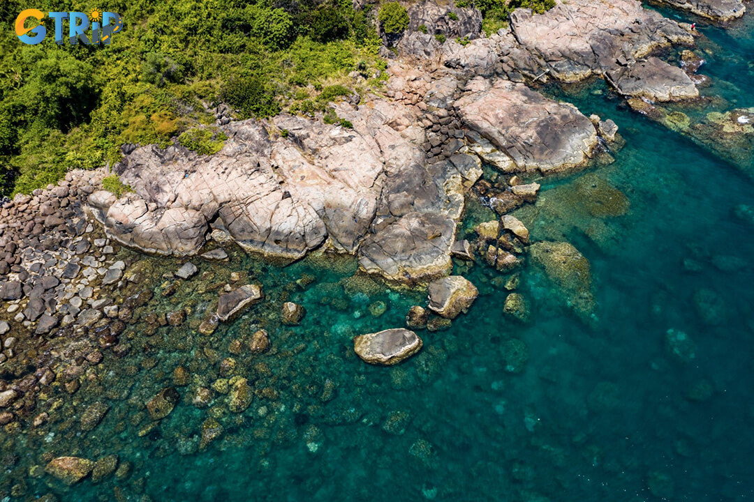 A dream for photographers, Ghenh Bang showcases jagged cliffs, layered rocks, turquoise water, and distant views of the Cham Islands for striking, untamed coastal shots