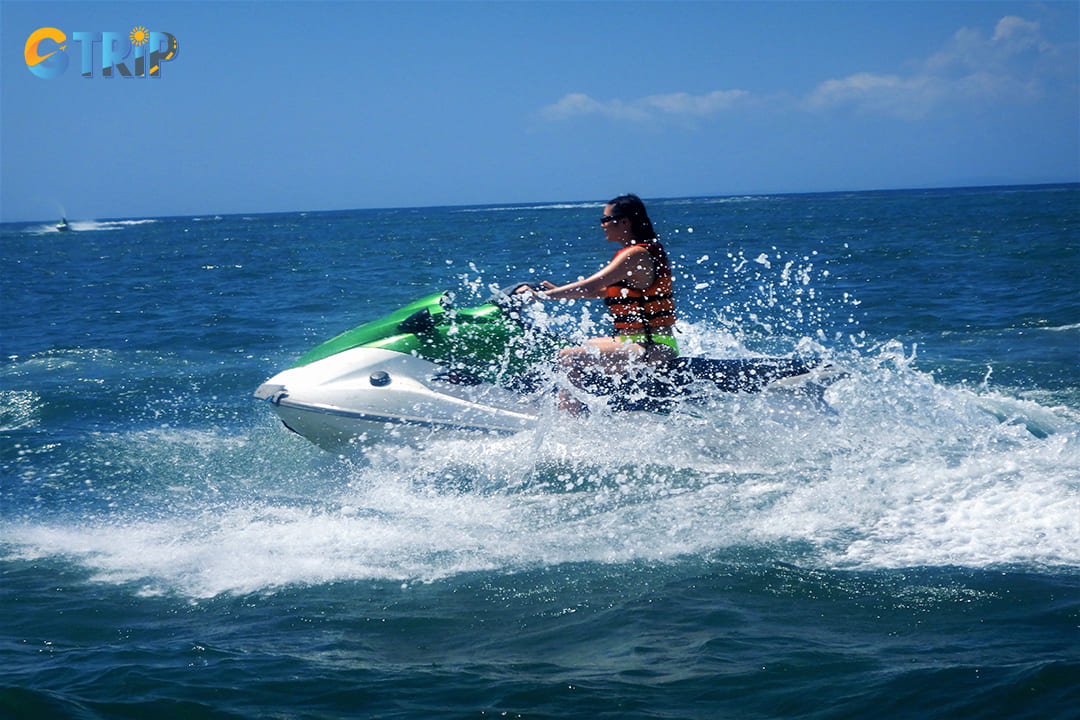 A woman is jet skiing and enjoying the fresh water