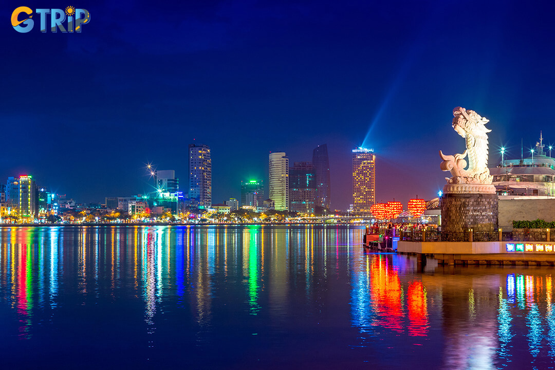 At sunset, colorful LED lights illuminate the statue, transforming the marina into a romantic, fairytale-like riverside scene