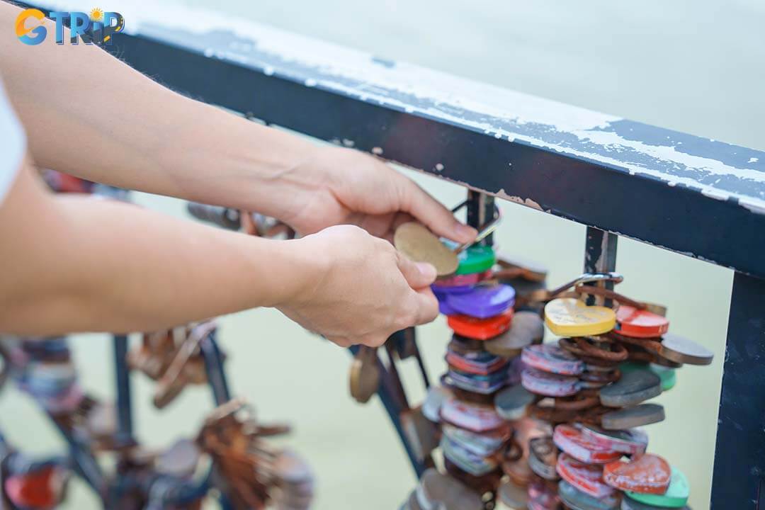 Attaching a love lock at Love Bridge is a symbolic ritual where couples and friends seal their bond by locking an engraved padlock to the railings