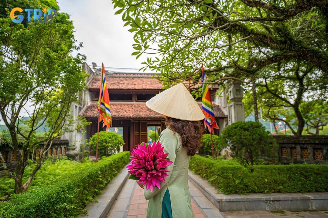 Back view of girl wearing ao dai in front of Hoa Lu Temples