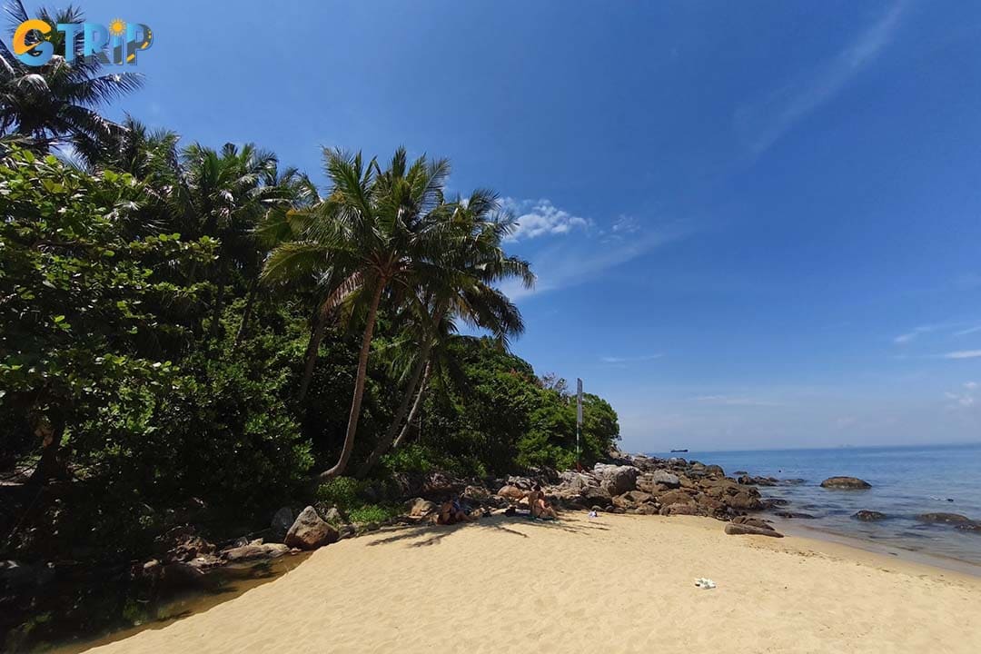 Bai Chong Beach is framed by lush green mountains and the calm, blue sea