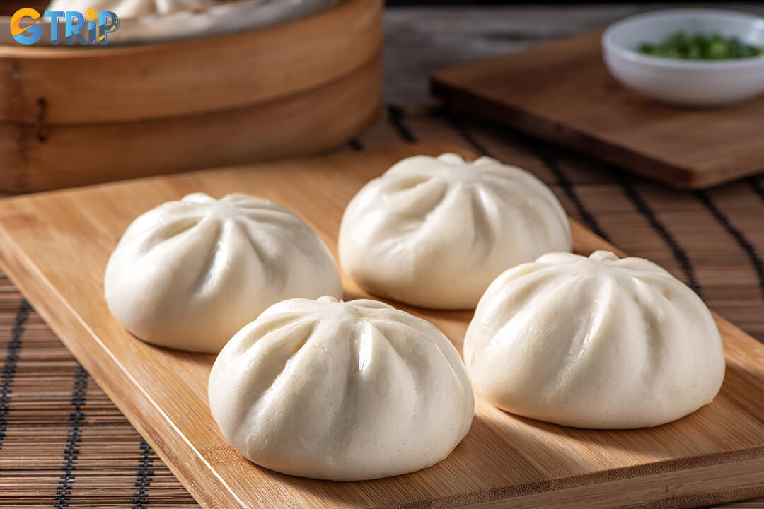 Banh bao soft steamed bun with savory pork filling, offers a warm, portable breakfast rooted in Hanoi’s Chinese culinary heritage
