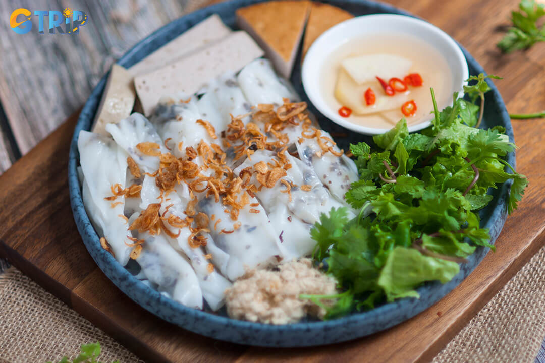 Banh cuon are delicate rice rolls filled with minced pork and mushrooms, topped with fried shallots, and served with sweet-tangy fish sauce