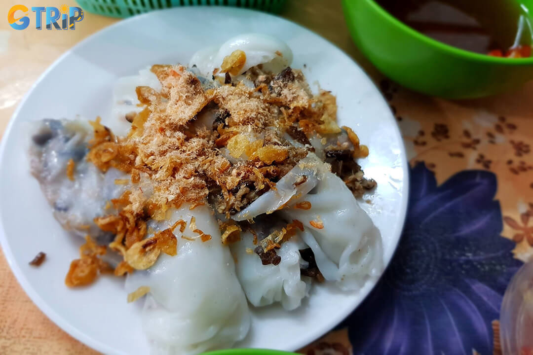 Banh Cuon Quang An is a hidden Old Quarter gem, known for its freshly steamed rice rolls, rich fillings, and vibrant evening street-food atmosphere