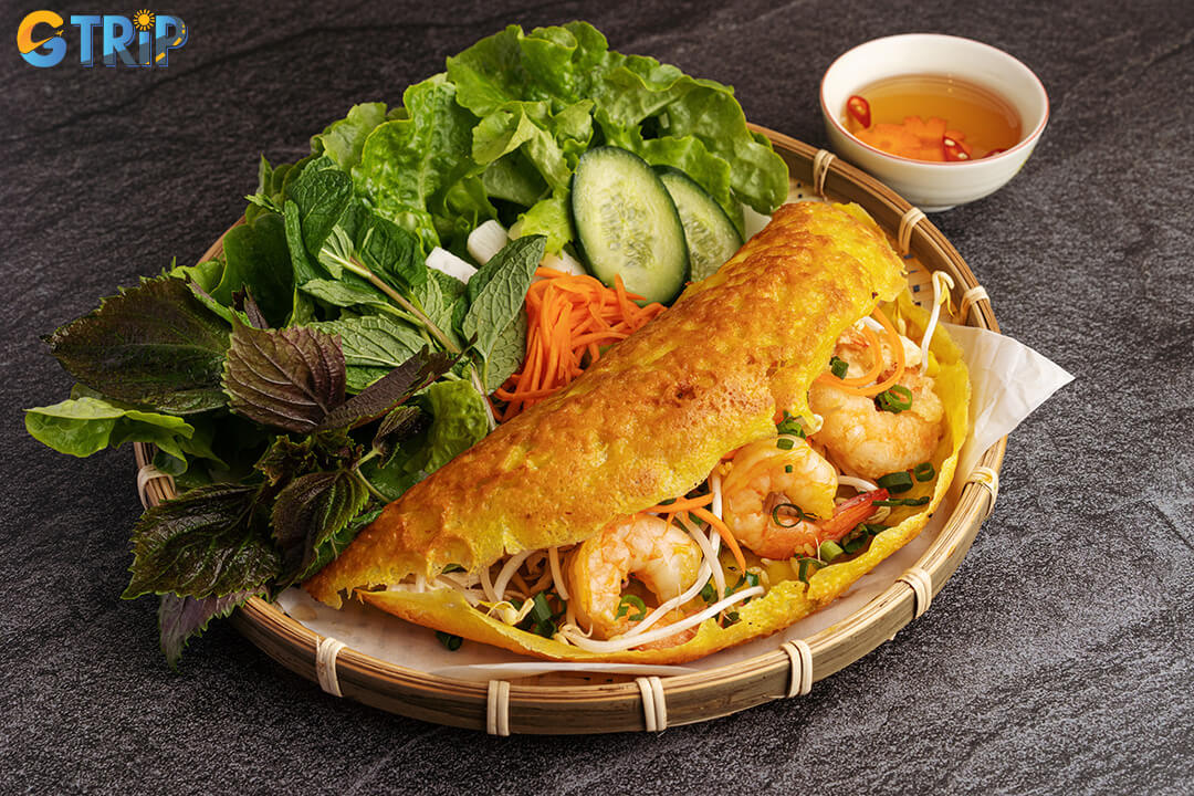 Banh Xeo is a must-try Vietnamese dish, loved for its sizzling crispy crepe, fresh herbs, and hands-on eating experience