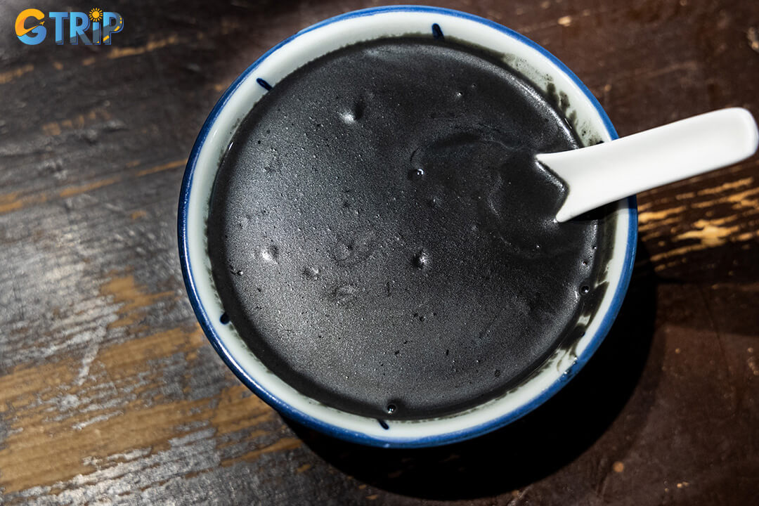 Black sesame soup (che me den or xi ma phu) is a traditional sweet dessert made from roasted sesame seeds, known for its smooth texture and nourishing herbal flavor