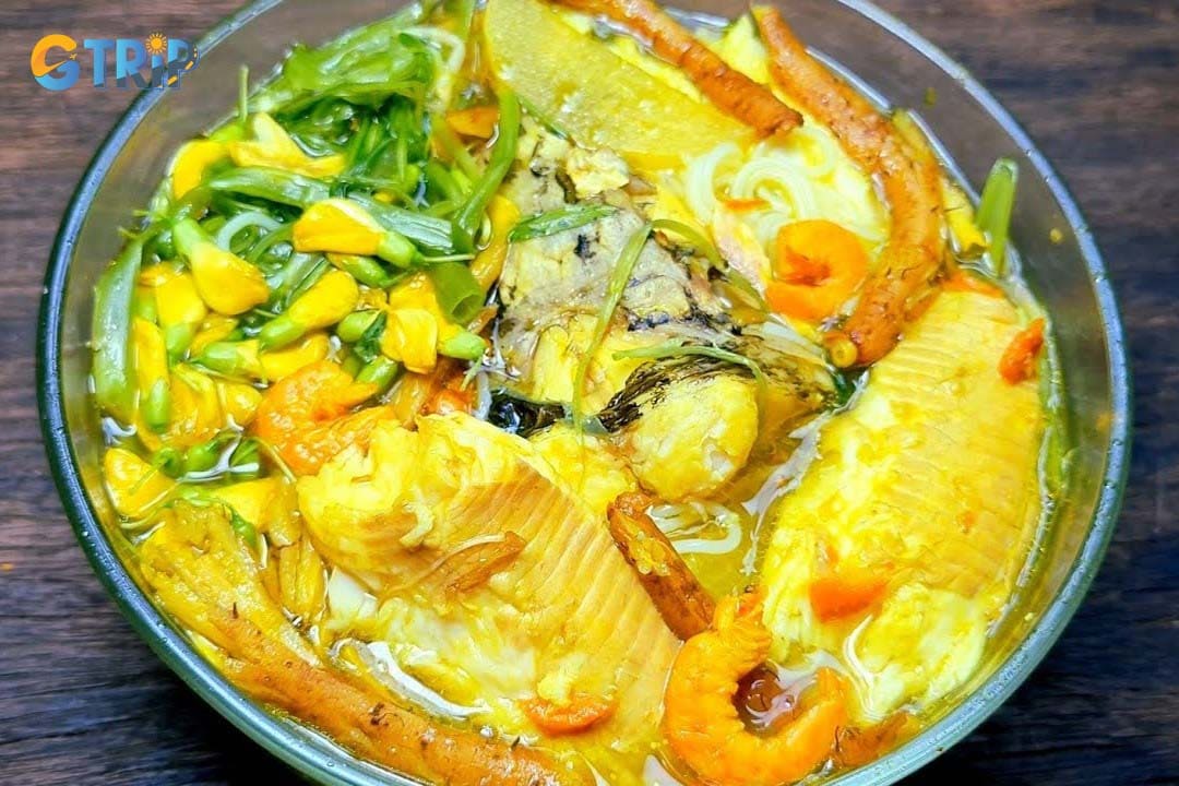 Bun Ca is a light Mekong Delta noodle soup featuring flaky fresh fish in a clear, tangy-sweet broth made from fish bones, tomatoes, and pineapple