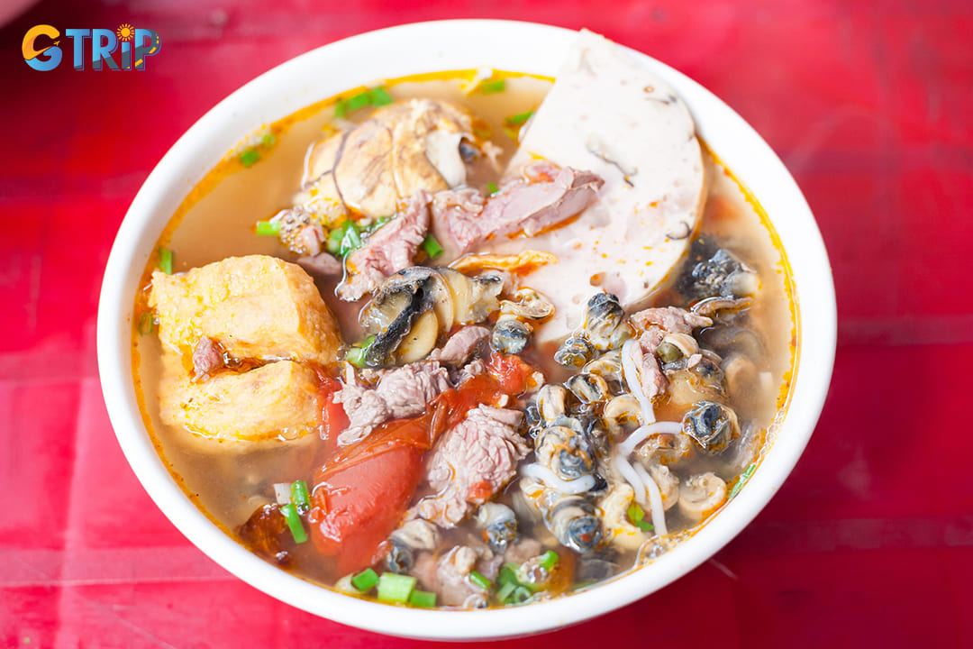 Bun oc is a beloved Hanoi specialty featuring river snails in a tangy tomato broth with rice vermicelli noodles