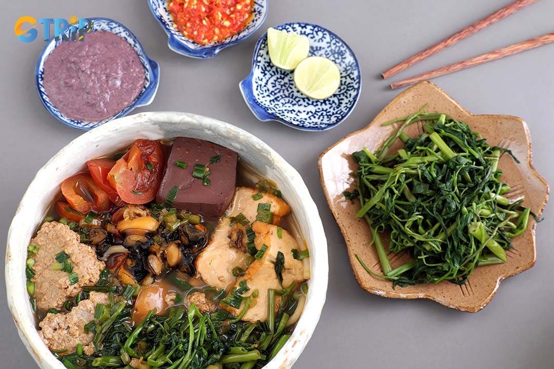 Canh Bun is a rustic Saigon favorite with a lighter crab-and-tomato broth, soft crab cakes, thicker vermicelli noodles, and plenty of blanched water spinach