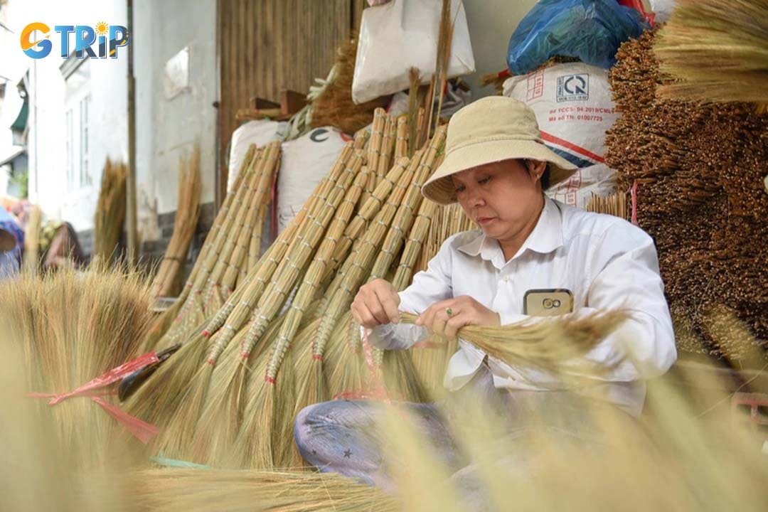 Explore Pham Van Chi Street’s traditional broom-making hamlet, where skilled artisans craft golden grass brooms by hand