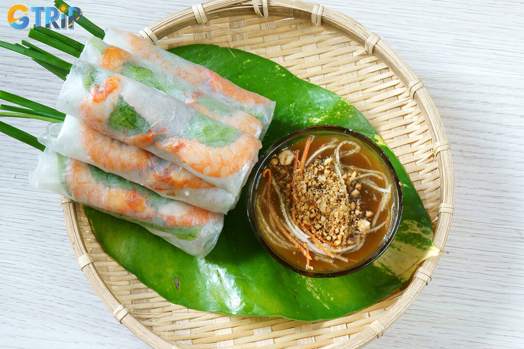 Goi cuon are fresh Vietnamese spring rolls filled with herbs, shrimp, and pork, served with a rich, flavorful dipping sauce