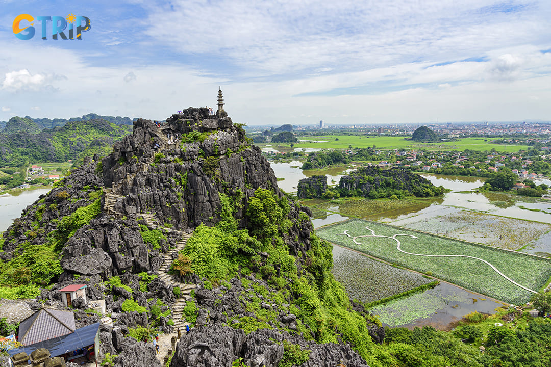 High angle view of a limestone peak against wetland and village at Mua Cave