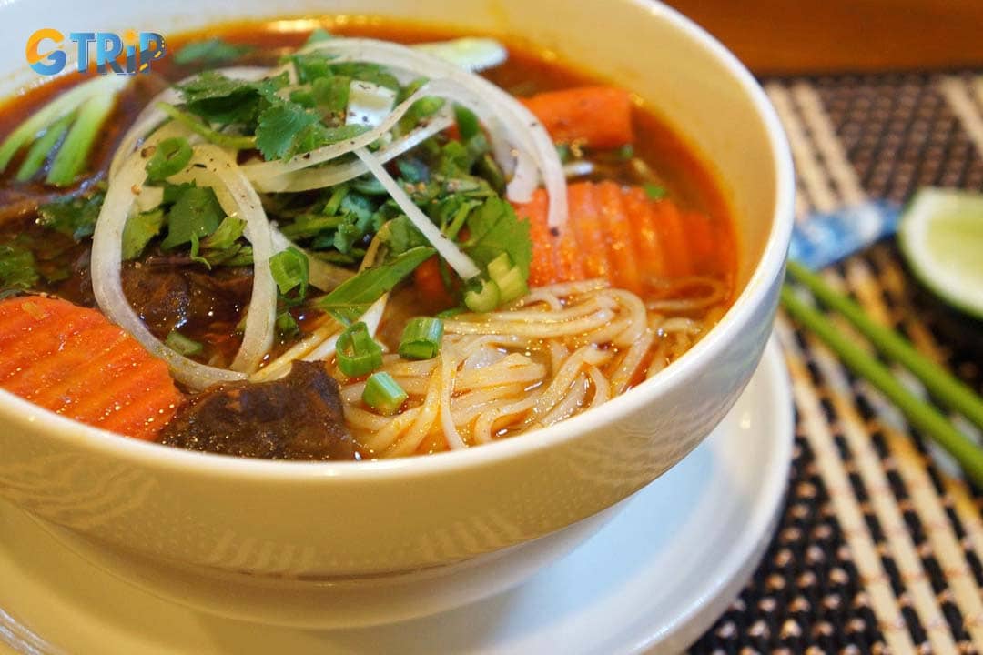 Hu Tieu Bo Kho is a Vietnamese comfort dish featuring chewy rice noodles in a rich, aromatic beef stew broth slow-cooked with tender beef, carrots, and warm spices