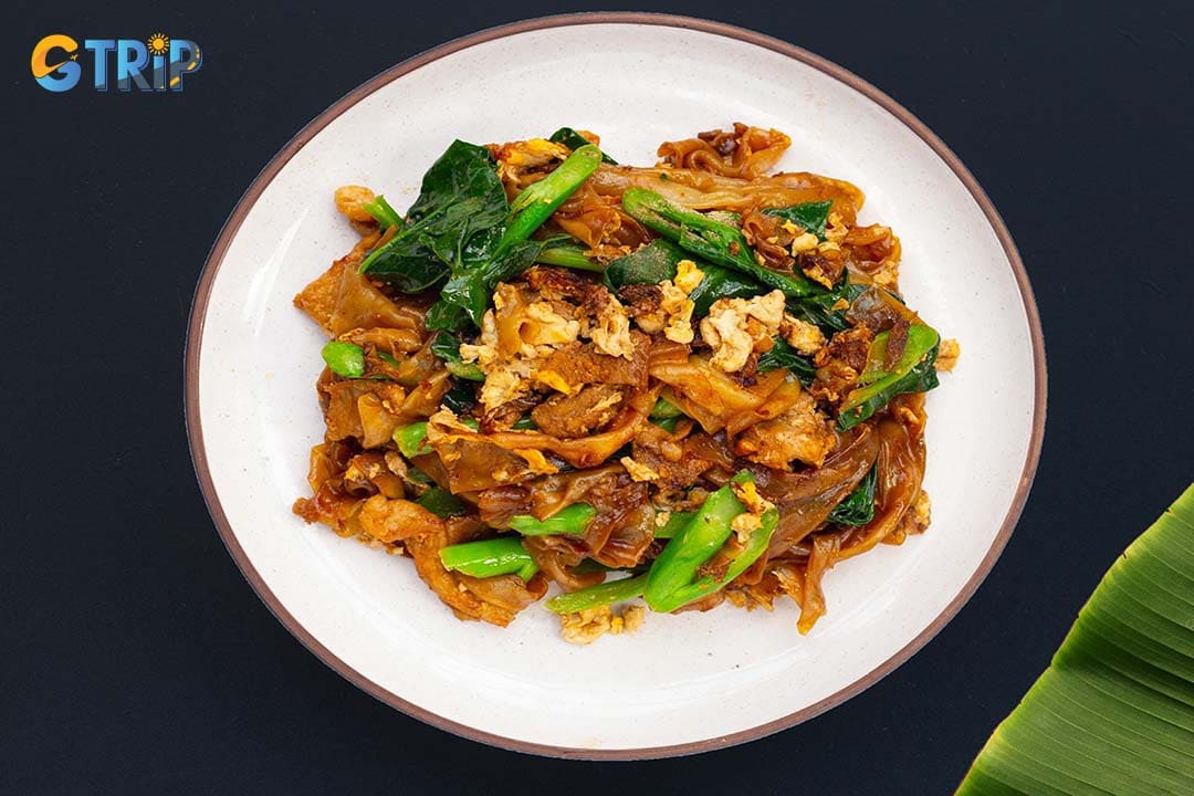 Hu Tieu Xao is a smoky, wok-fried noodle dish where soft rice noodles are stir-fried with savory sauce, mixed seafood or pork, and crisp vegetables