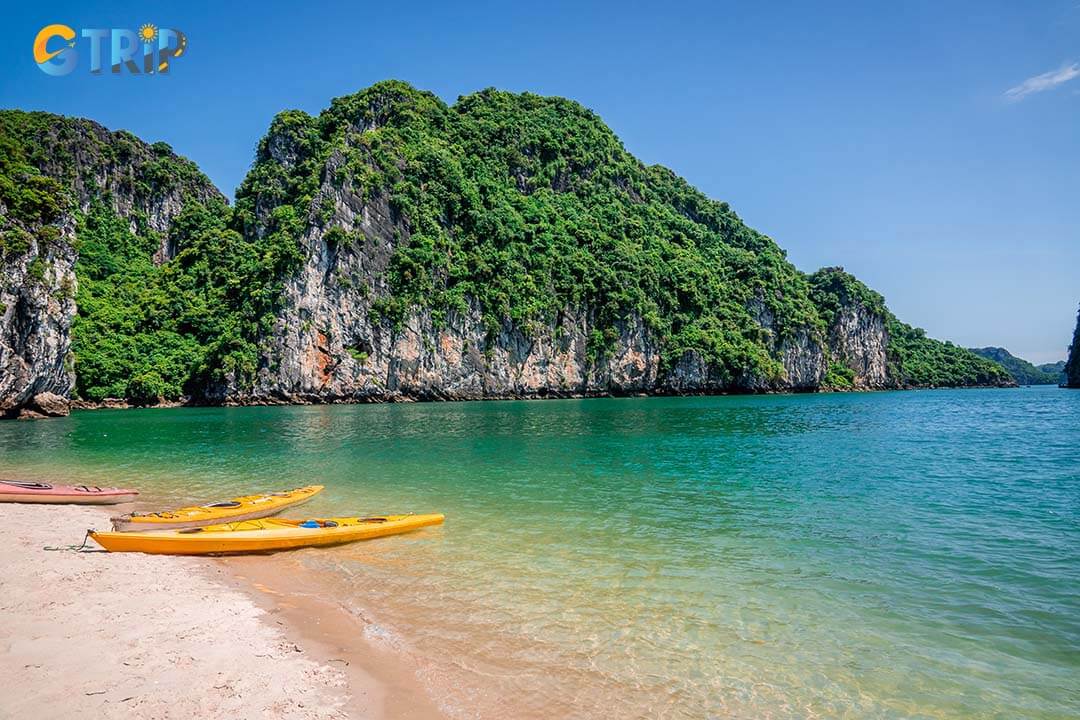 Kayaks at the shore of the limestone peaks in Bai Tu Long Bay