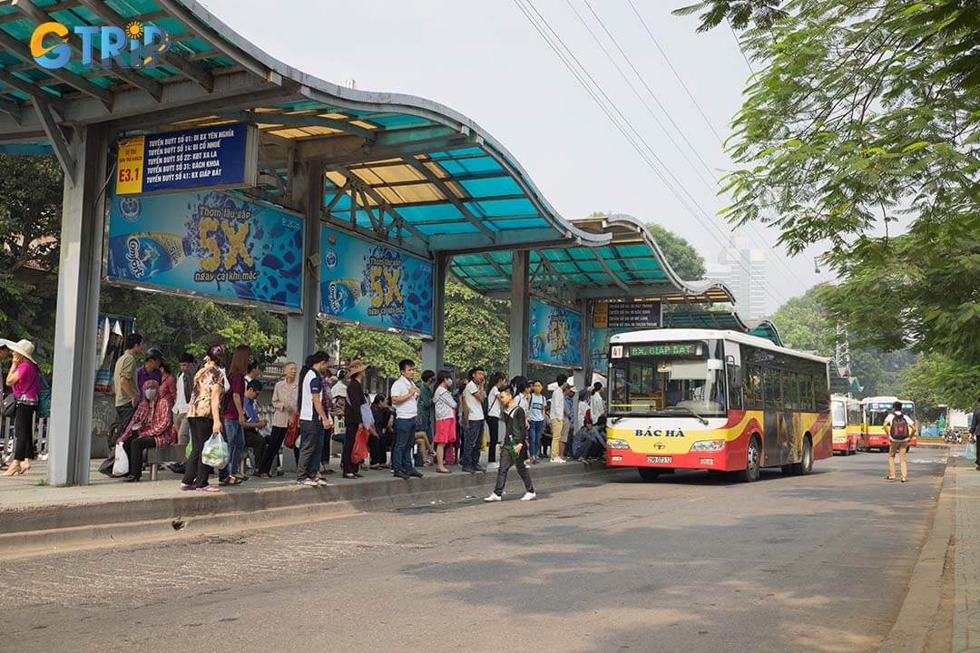 Line of people waiting for bus at bus station in Hanoi City