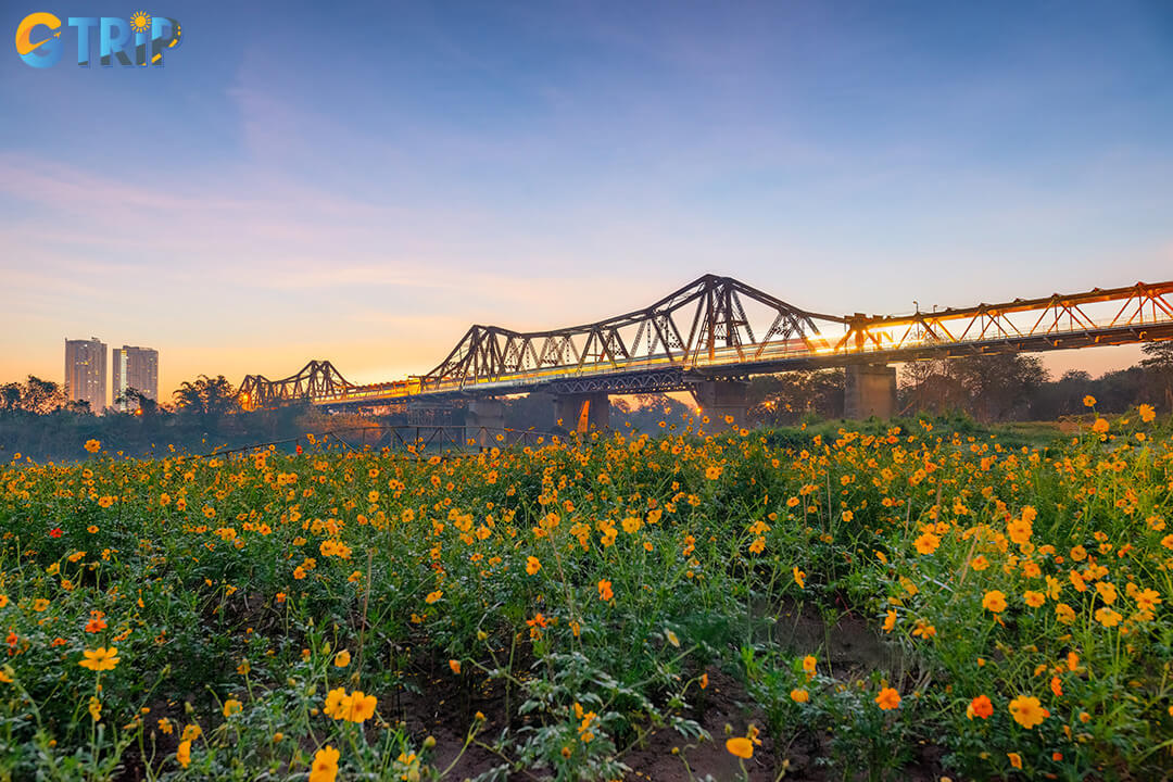 Long Bien Bridge offering golden sunsets, bustling markets, and peaceful riverside views that reflect Hanoi's seasonal charm