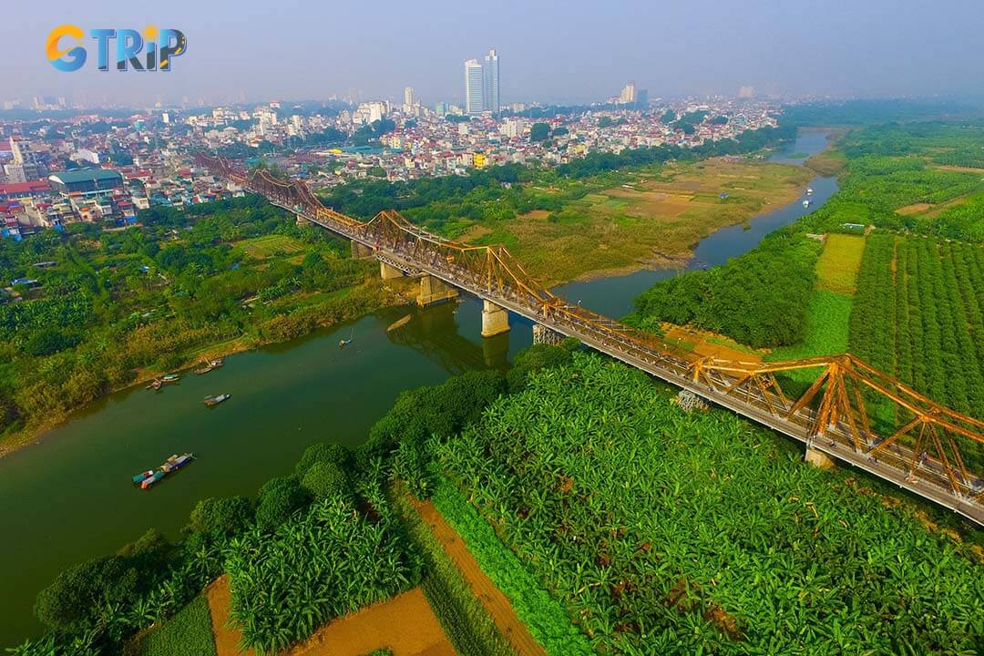 Spanning 2,290 meters, Long Bien Bridge’s narrow steel frame supports trains, vehicles, and pedestrians, forming a dragon-like silhouette over the Red River