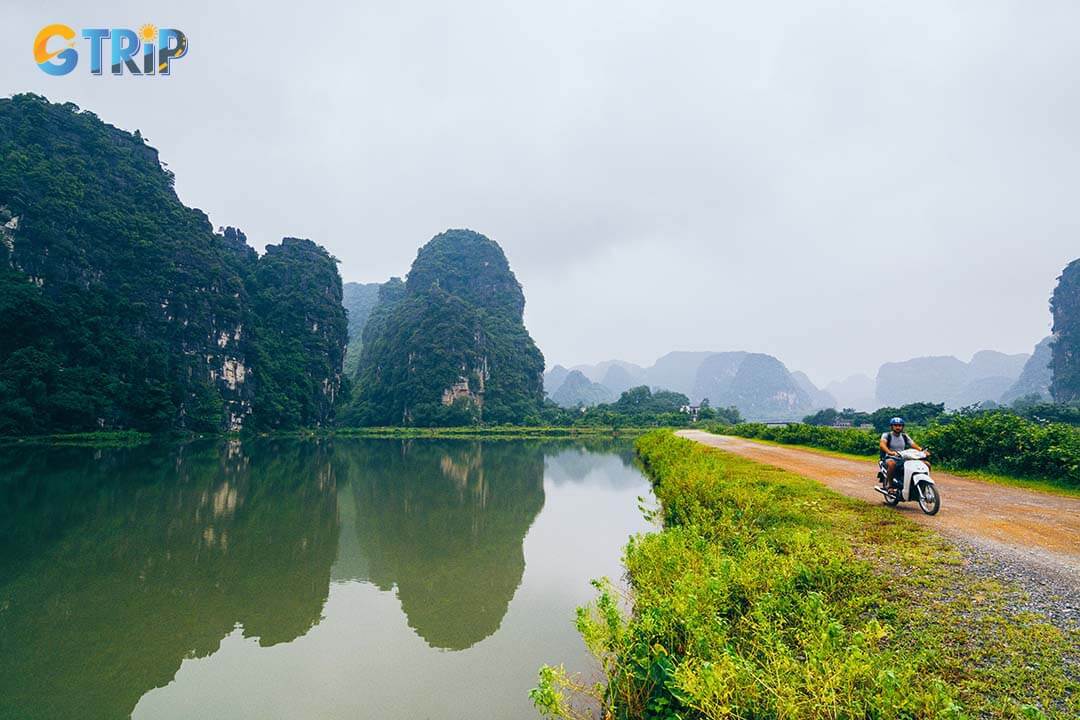 Man riding motorcycle among limestone mountains