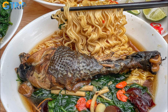 Mi ga tan is a Hanoi favorite, featuring chicken noodle soup simmered with medicinal herbs for a fragrant, nourishing broth