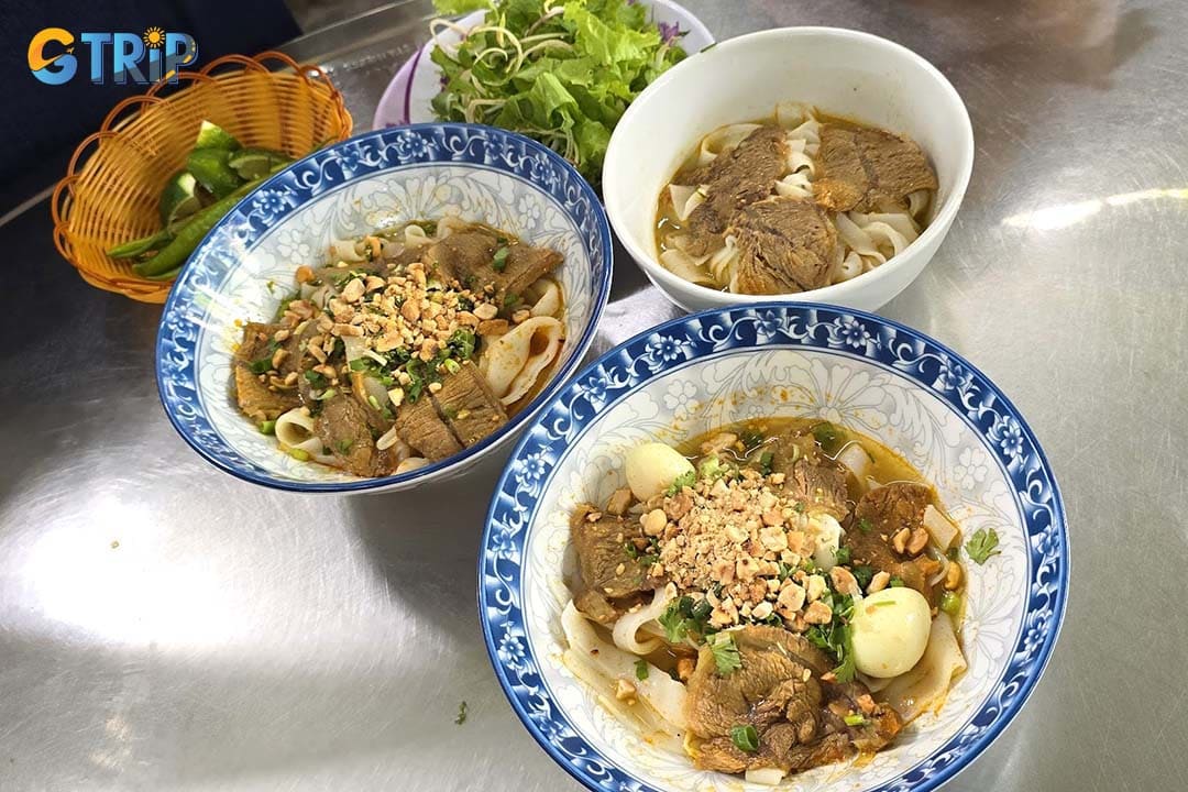 Mi Quang Ba Anh is a beloved local breakfast spot serving flavorful varieties like chicken, beef, shrimp-pork-quail egg, and mixed mi quang