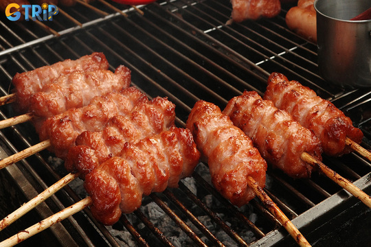 Nem nuong is Hanoi’s smoky grilled pork roll, enjoyed alone or wrapped with herbs and rice paper for a sweet-savory street food favorite