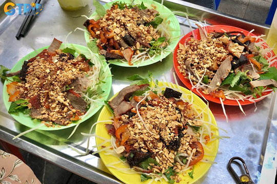 Nom kho bo is a nostalgic Hanoi snack of shredded green papaya tossed with dried beef, herbs, peanuts, and a sweet-tangy-spicy dressing