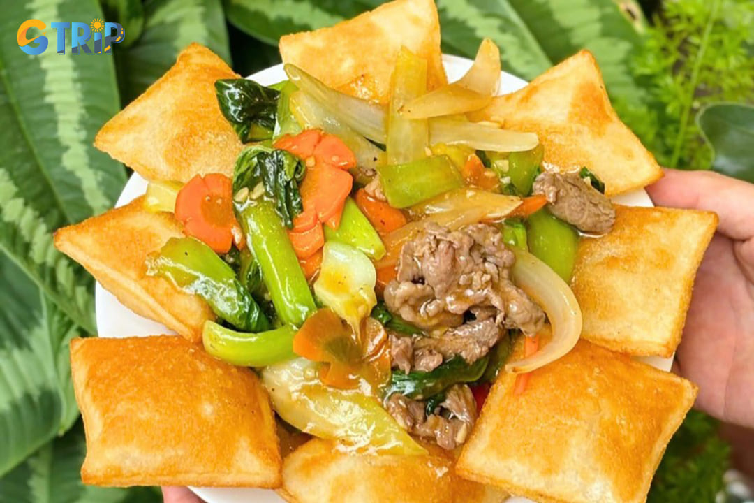 Pho chien phong represents pho's indulgent side, crispy deep-fried rice noodle squares topped with stir-fried beef, vegetables, and a savory gravy