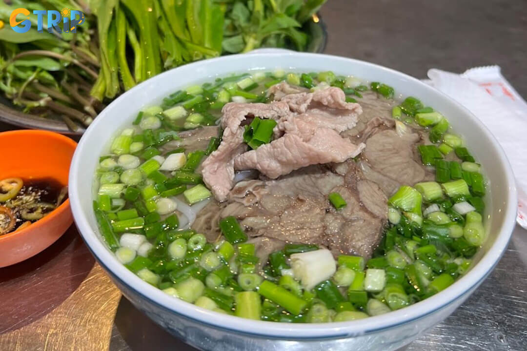 Pho Tau Bay, a historic Northern-style pho spot since 1954, is loved for its clear, light broth and tender rare beef in a rustic, no-frills setting