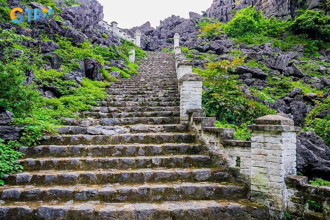 Stone staircase ascending the lying dragon mountain to reach the Mua Cave