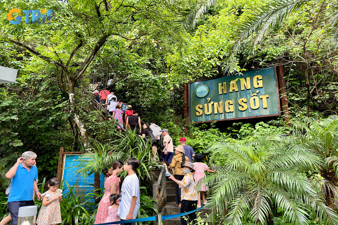 Tourists are climbing to reach the entrance of the cave