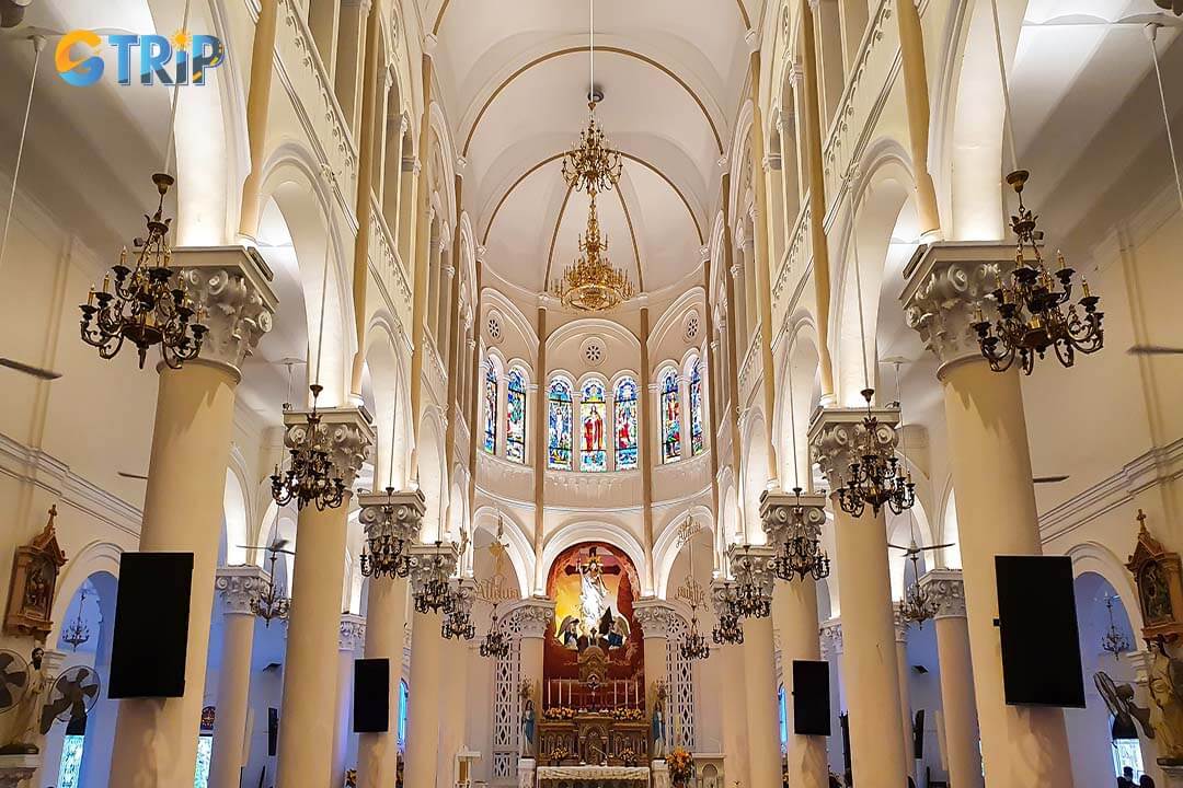 Tan Dinh Church blends Romanesque, Gothic, and Renaissance styles, featuring a striking pink facade, a 52.6-meter spire, and intricate interior details