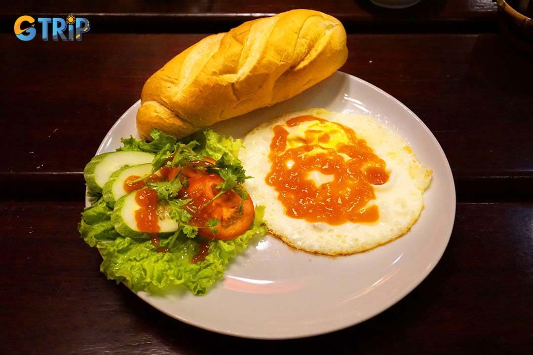 The Banh Mi op la features sunny-side-up eggs seasoned with soy sauce, their runny yolks soaking into the warm baguette