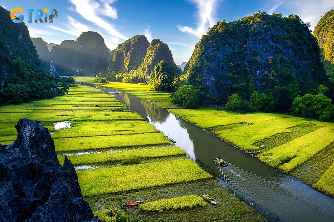 Take a boat ride in Tam Coc, gliding through limestone karsts, rice fields, and iconic caves