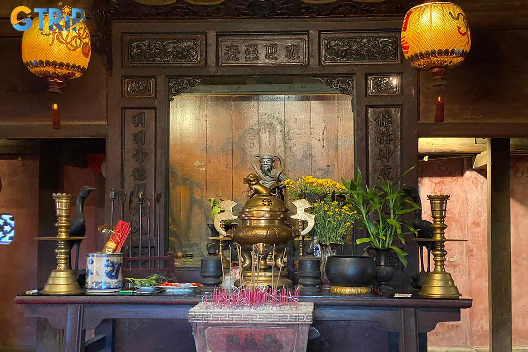 The ground floor features a traditional merchant layout supported by 80 ironwood columns, showcasing intricate carvings and antiques that reflect Hoi An