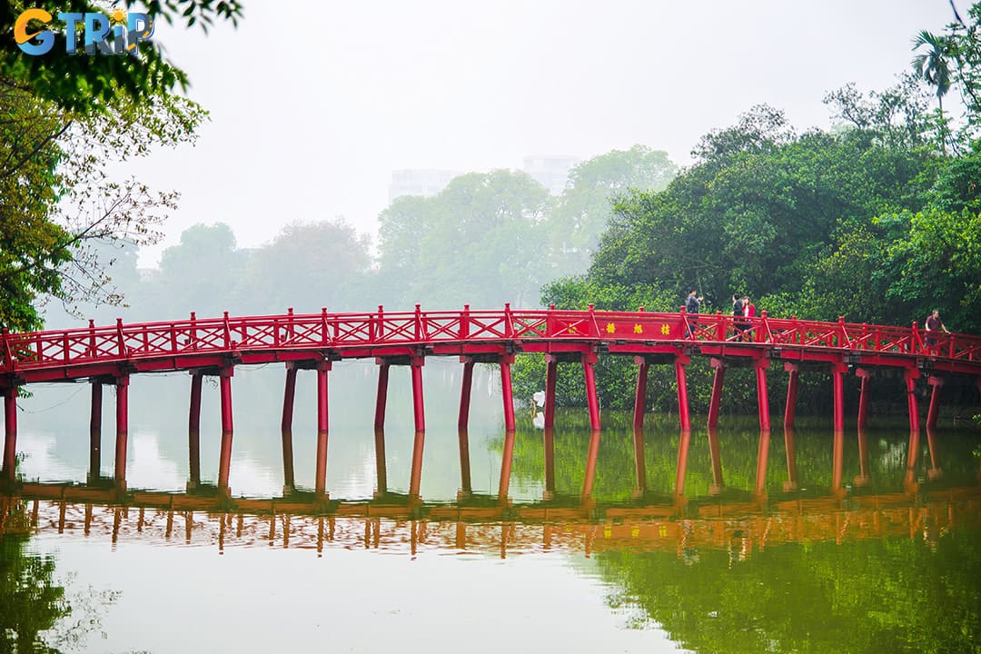 The Huc Bridge, a graceful red wooden span built in 1865, links Hoan Kiem Lake’s shore to Ngoc Son Temple, symbolizing Hanoi’s history, culture, and enduring spirit