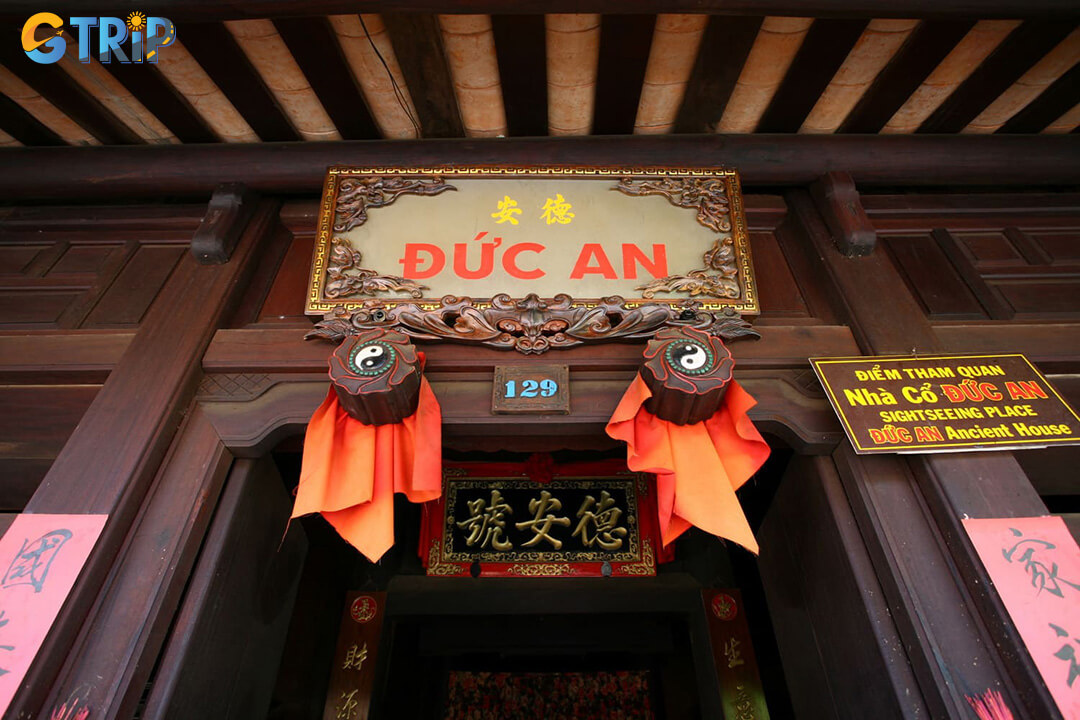 The main entrance features traditional four-panel doors, symbolic “door eyes” and removable wooden panels that reflect classic Hoi An merchant house design