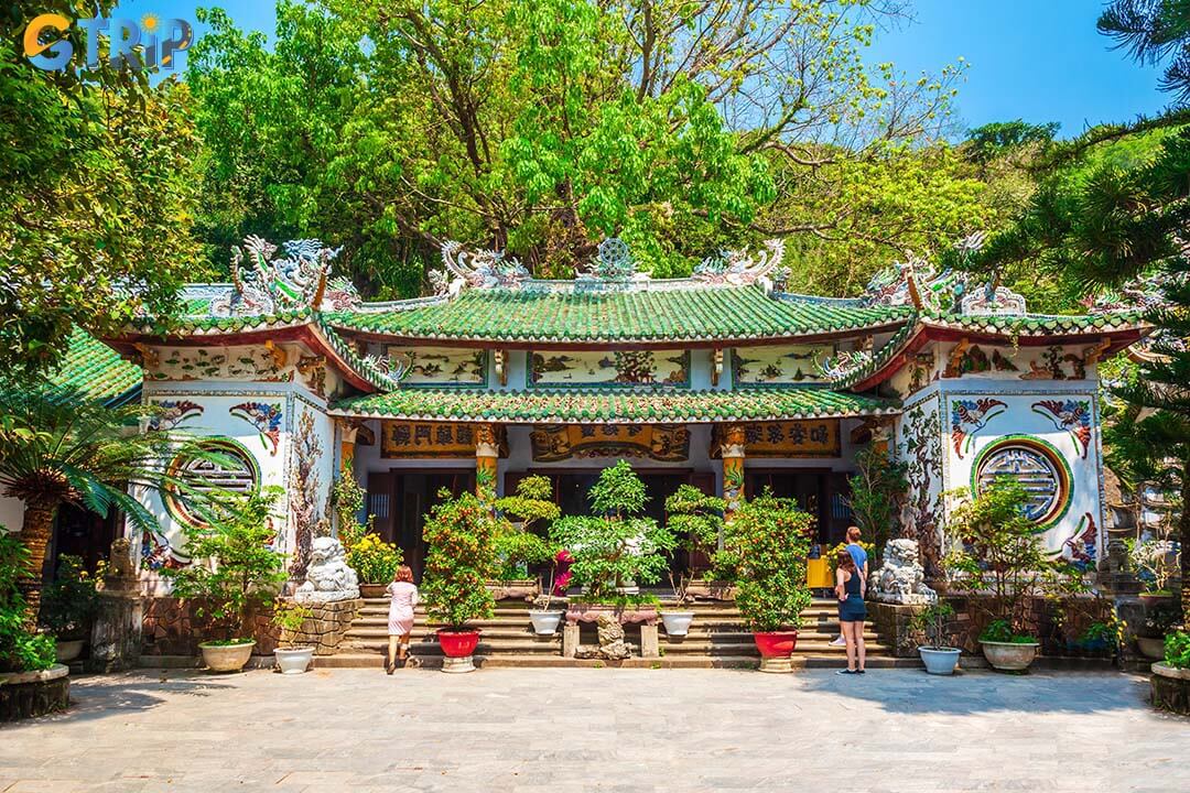 The main worship hall features a Shakyamuni Buddha altar, carved ironwood columns, and historic Han - Vietnamese inscriptions
