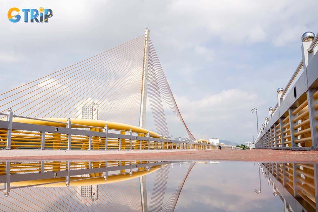 The Nguyen Van Troi Bridge features simple yet durable Poni truss steel frames and a low, grounded profile, with its iconic golden-yellow paint