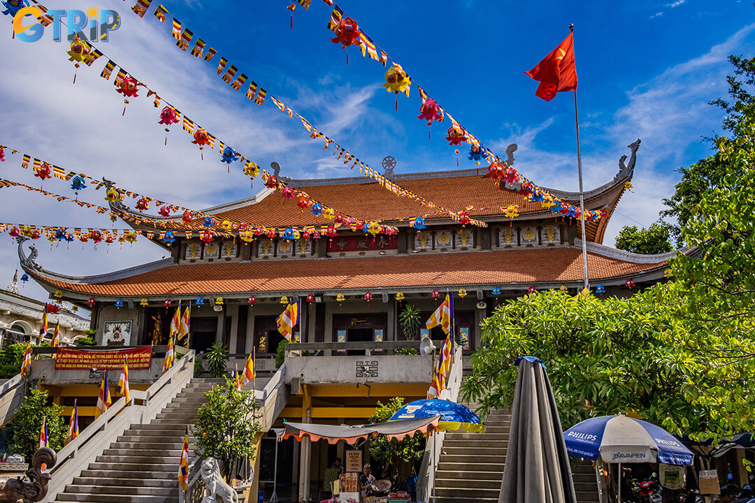 The two-story Main Hall of Vinh Nghiem Pagoda, with its grand roofs, intricate woodwork, and towering Buddha statues
