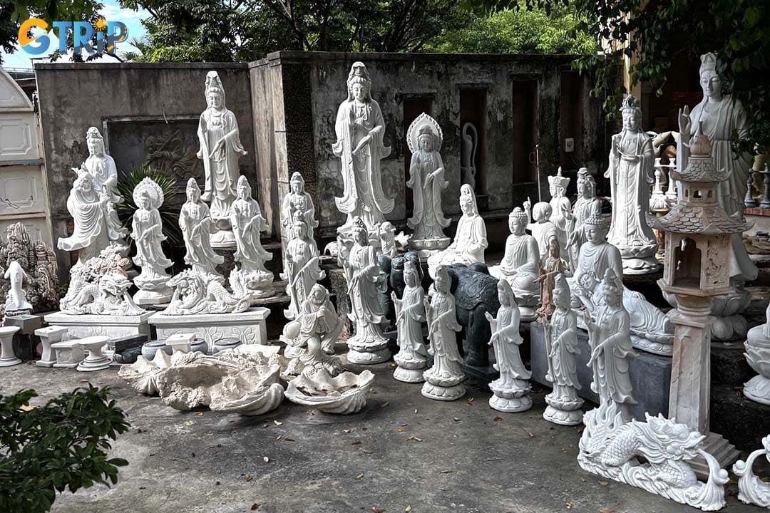The village unfolds like an open-air gallery, where workshops display intricately carved Buddha statues, polished modern sculptures, and imposing garden lions