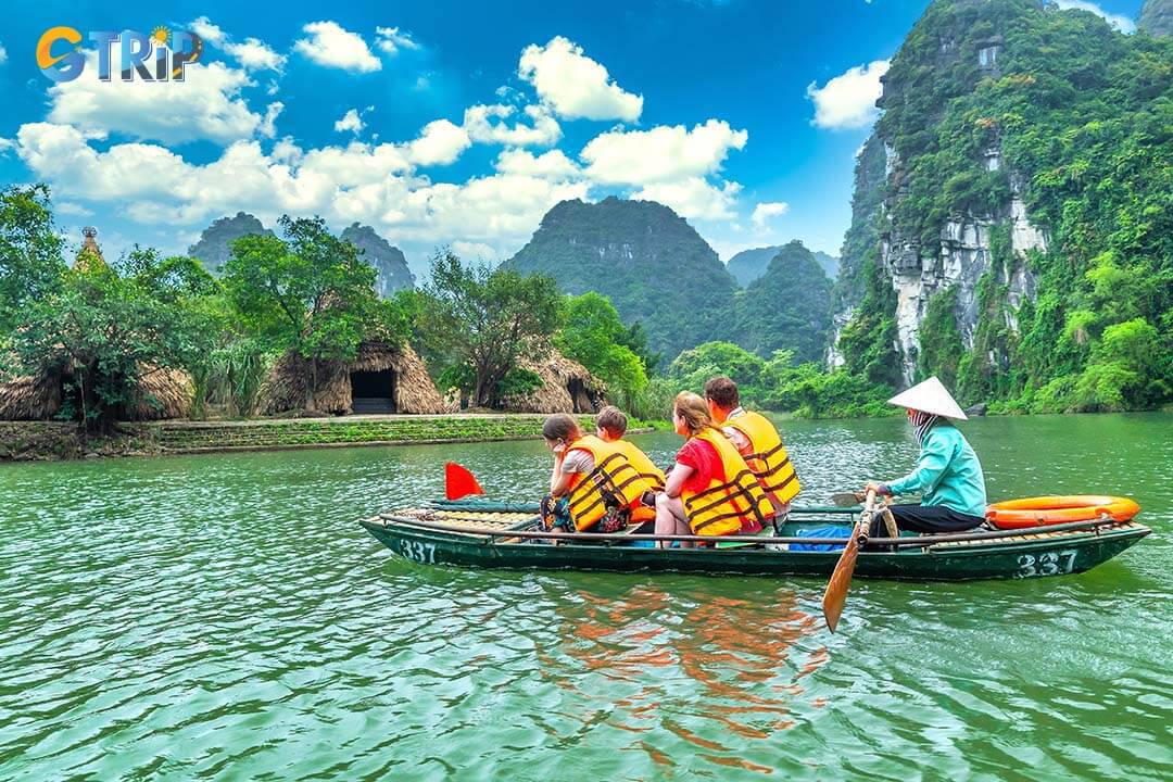 Tourists float by boat on the river of the Tam Coc