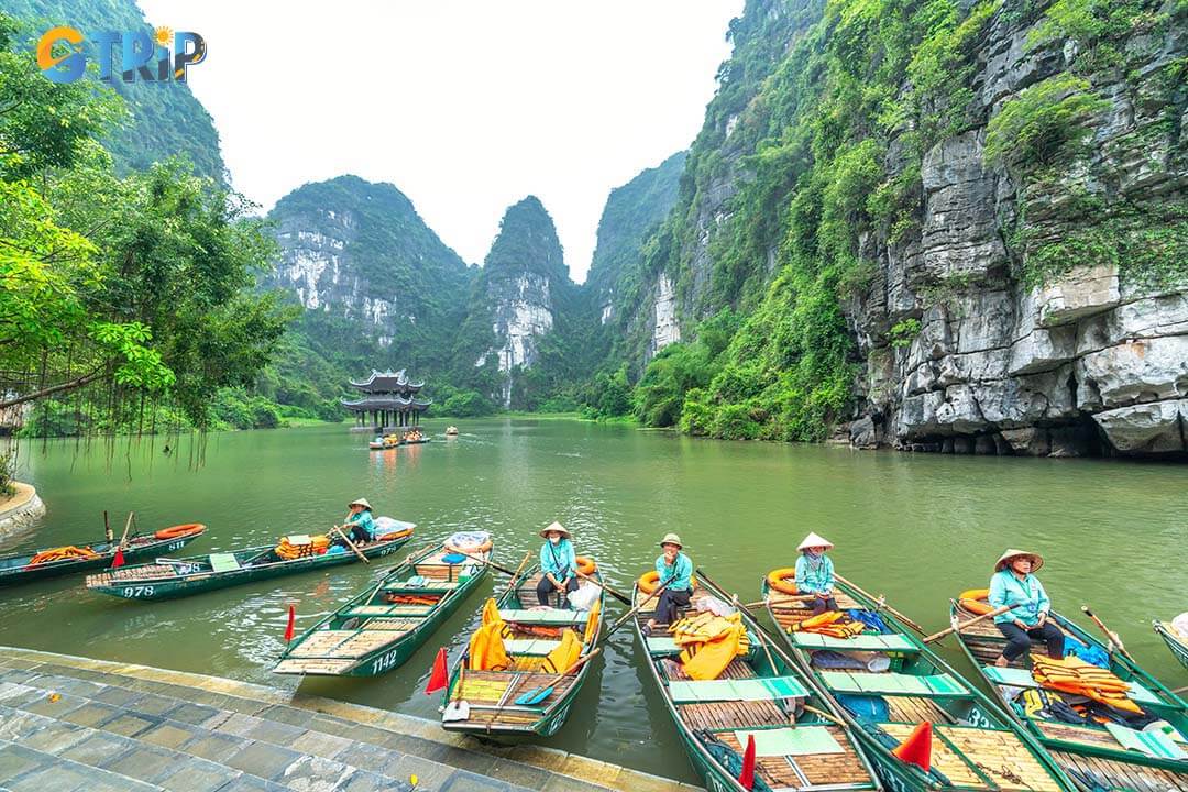 Tourists float by boat on the river of the Tam Coc