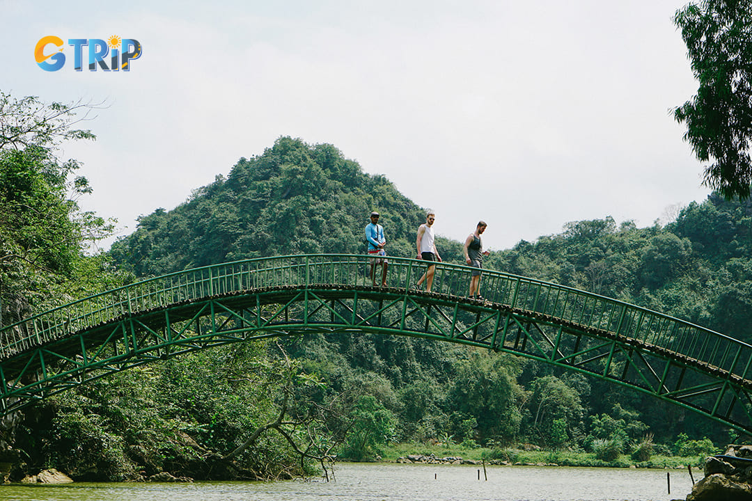 Tourists crossing the bridge across the lakeside in Am Tien can create wonderful photos