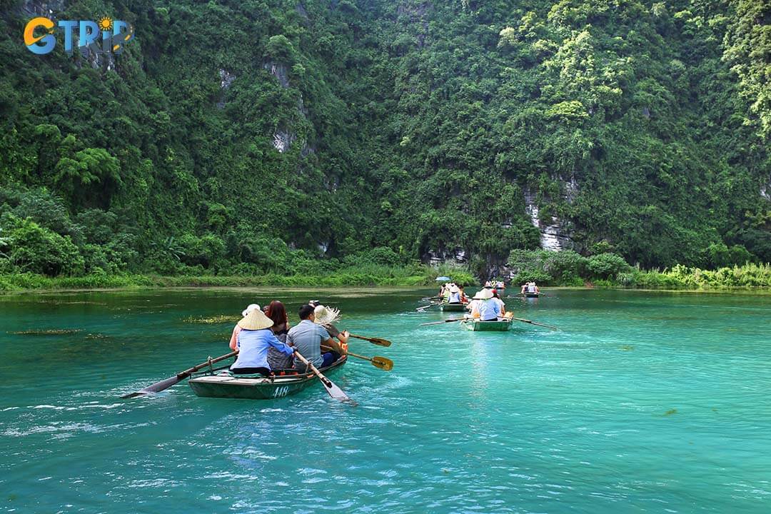 Visitors explore the Trang An Scenic Complex by boat, drifting through mystical caves and breathtaking waterways