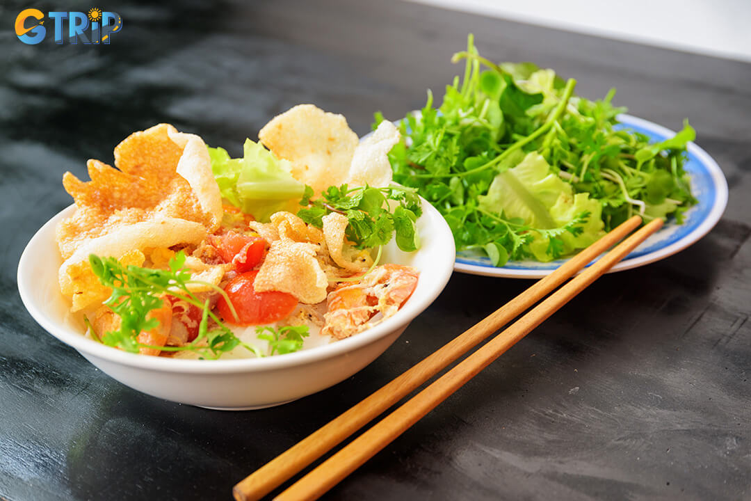 Tuy Loan’s legendary mi quang features freshly handmade rice noodles from local fields, served in a rich turmeric broth with meat, herbs, peanuts, and crispy rice paper